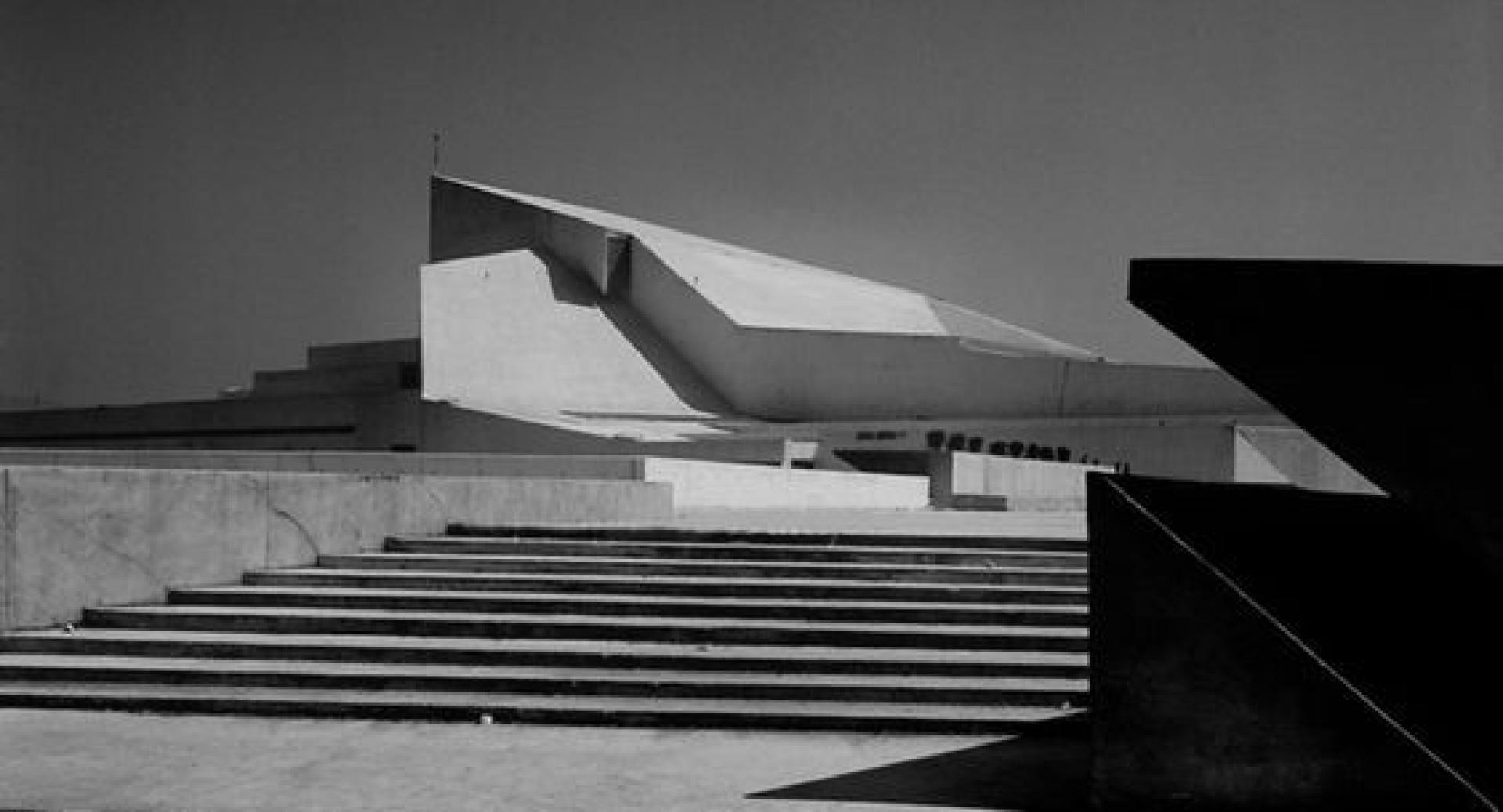 The building is emphasized by the absence of color, while the concrete forms a new white landscape incorporated in the tissue of the city. | Photo via Marh