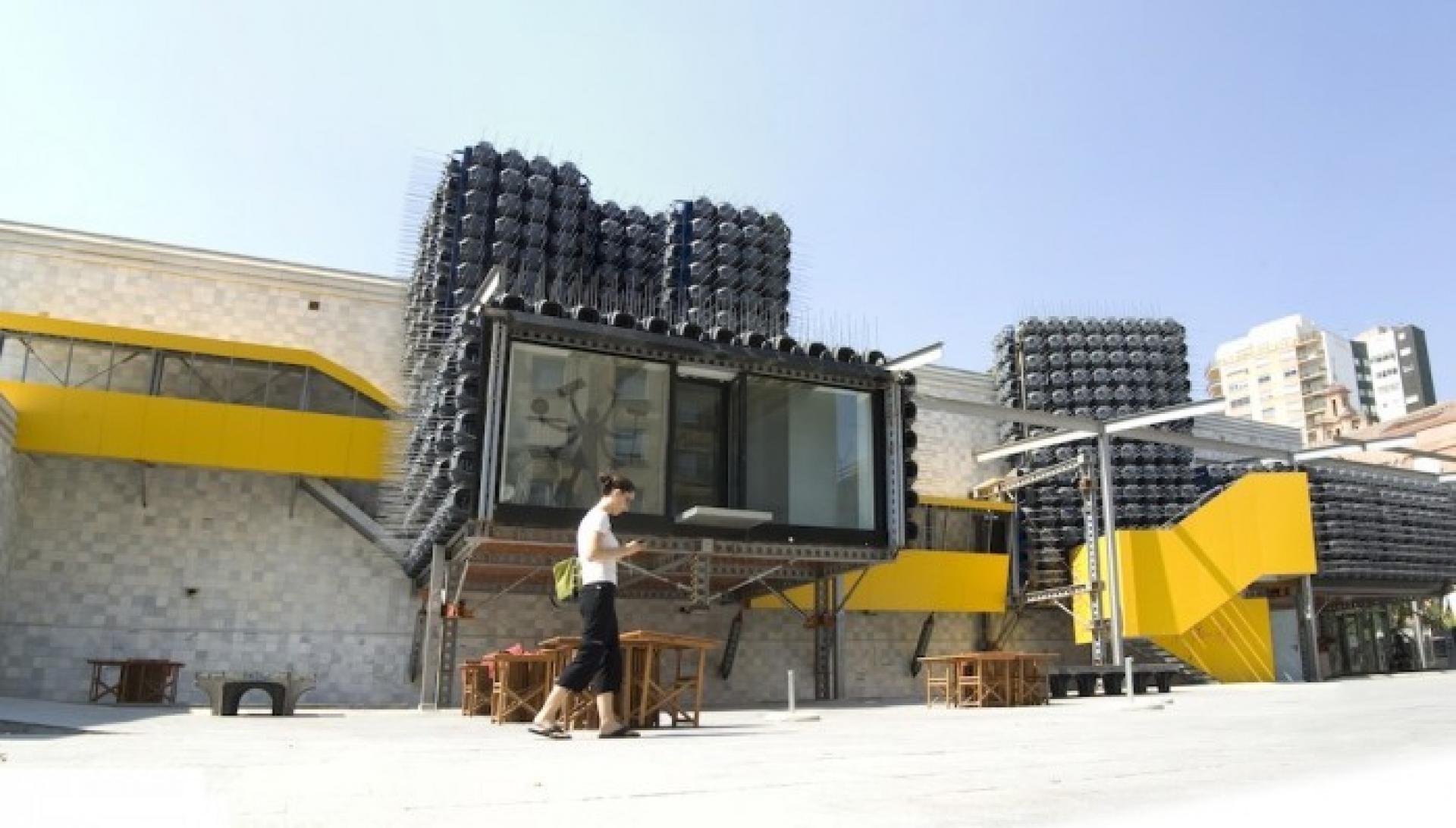 The rooms are covered by a skin of black plastic components used as concrete modules, each pierced by four metallic sticks. | Photo via Design in Daba