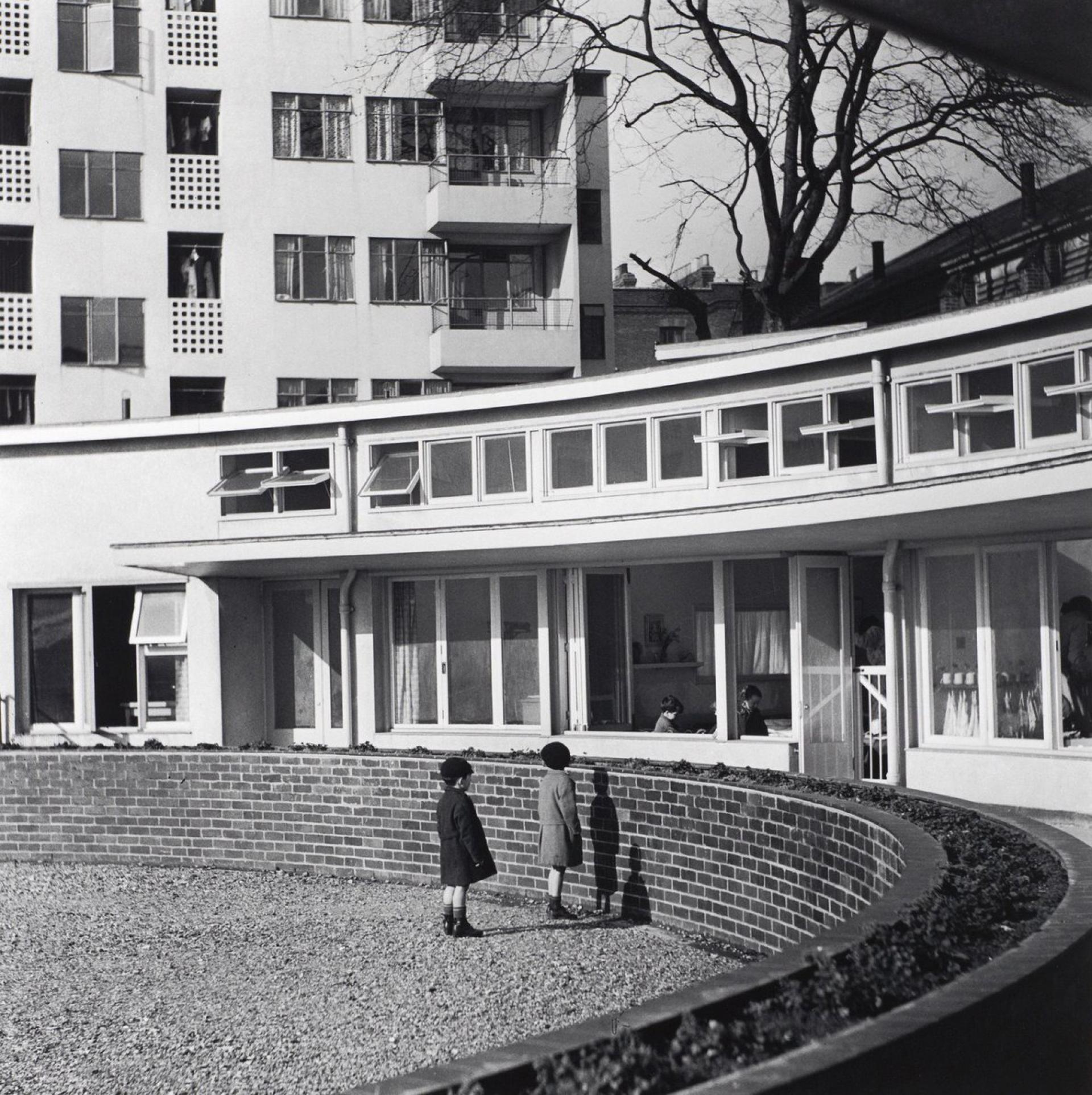 Fry and Denby used Kensal House to put into practice Modernist ideas for social change starting at home, offering carefully-planned flats with generous kitchens, bikes storages, gardens, large balconies and nursery. | Photo by Edith Tudor Hart at RIBA Collections