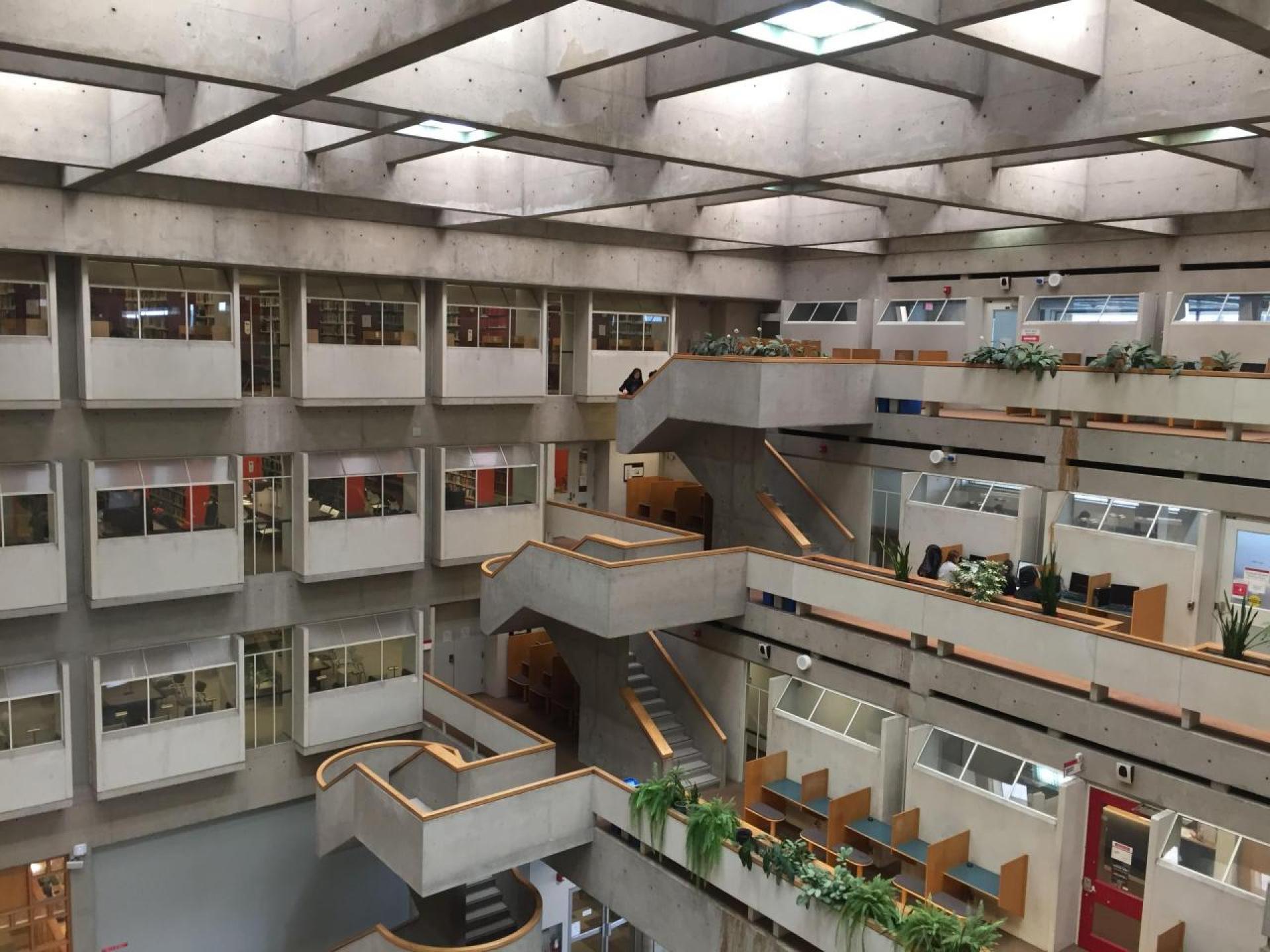 An austere inverted concrete ziqqurat to the outside, the indoors reveals a vast lobby towards which administrative and librarian offices are organized through a system of semi-public terraces with reading spaces. | Photo via FIG projects