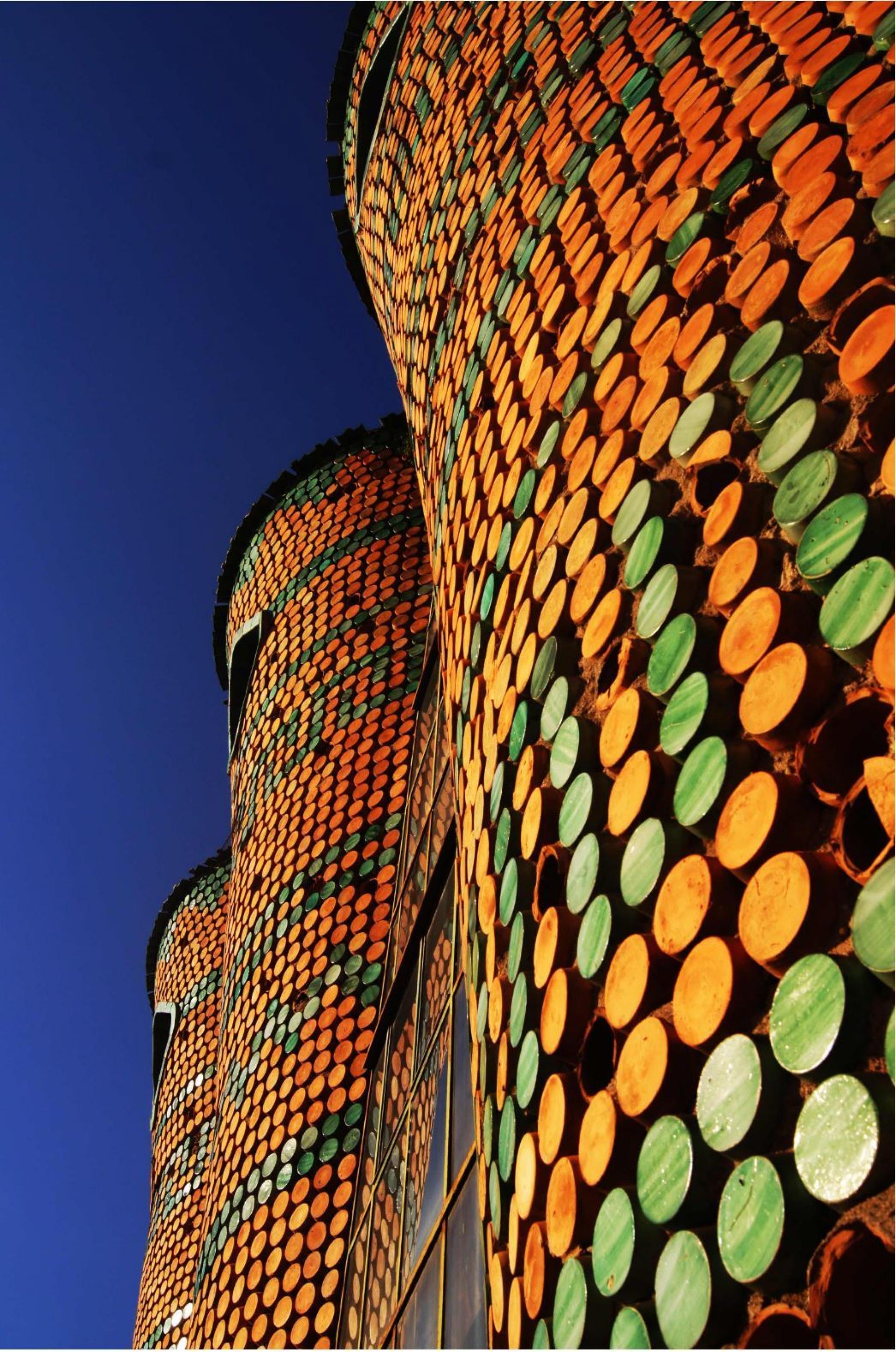 Circular bases of round terra-cotta vases are embedded in the concrete cladding and decorate the facade. | Photo © Luca Bullaro