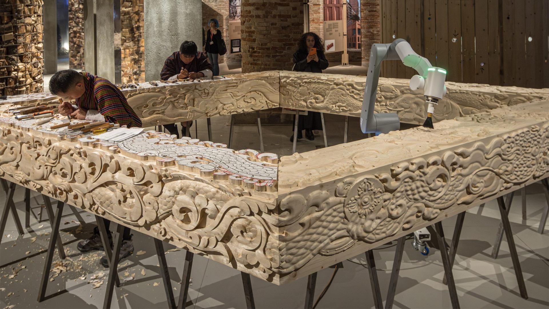 Human craft vs AI 2: Bhutanese craftsmen (left) train an AI robot (right). © Courtesy by Dezeen